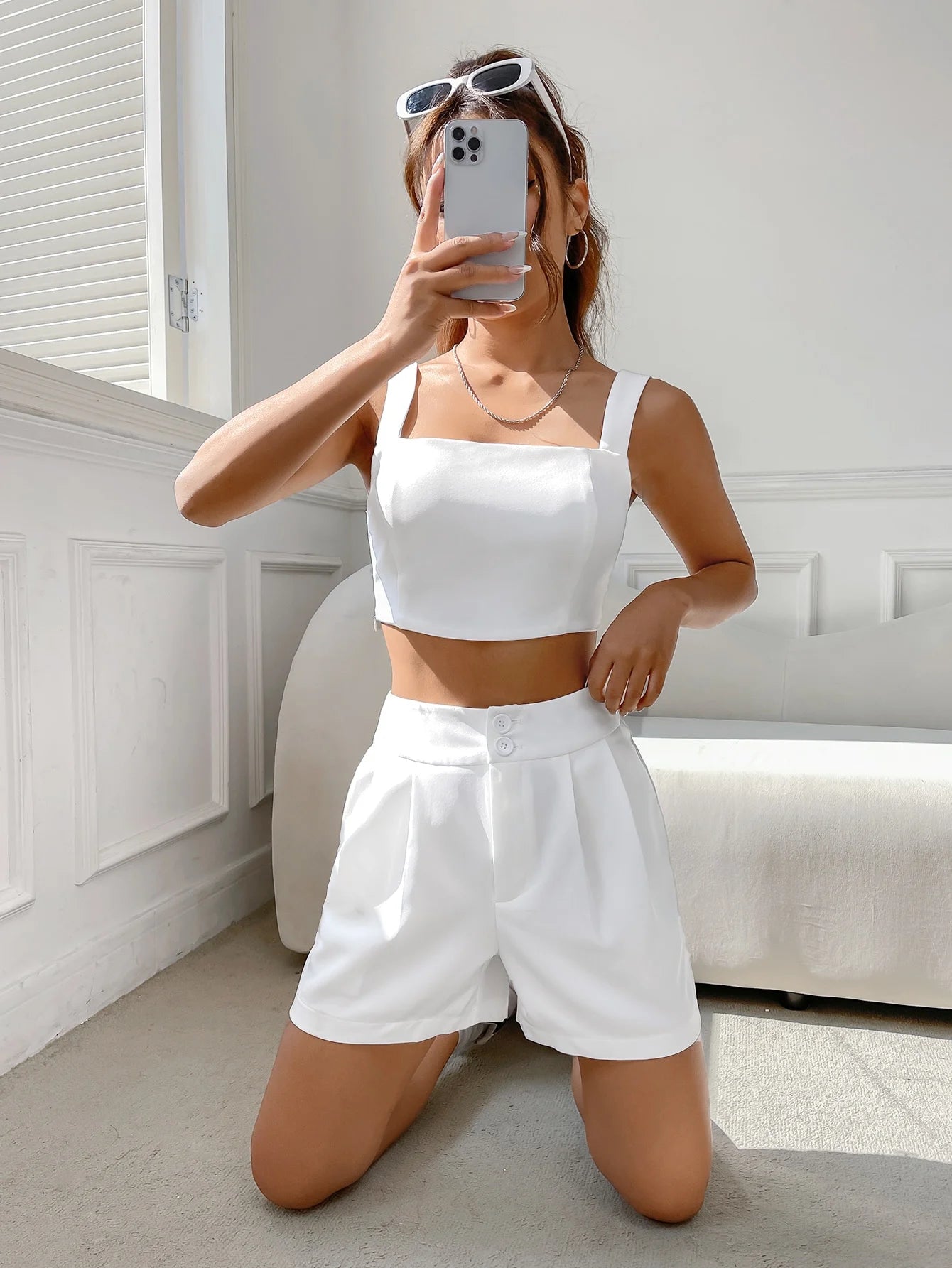 A casual suit for women with a one-neck halter top and white shorts