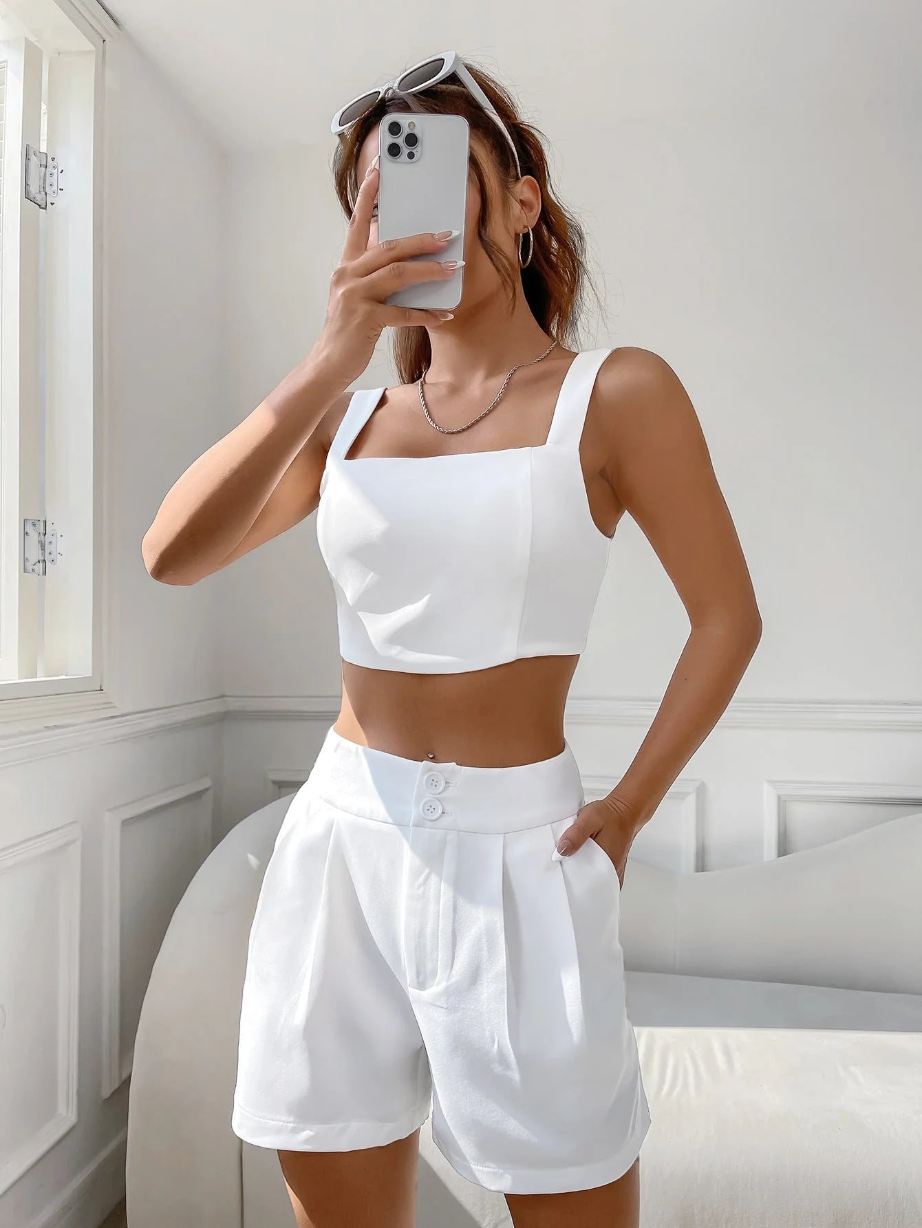 A casual suit for women with a one-neck halter top and white shorts
